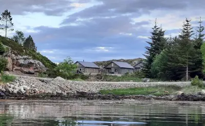 a group of houses on the shore of a river at Atlanterhavsveien Rorbuer in Averoy