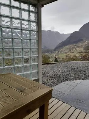 a wooden bench sitting on a porch with a view of a mountain at Sognevegen 2242 in Haugsvær
