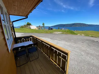 a balcony with two chairs and a view of the water at Botnen Camping in Botnen