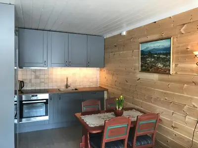 a kitchen with a table and chairs in a kitchen at Rondaplassen in Kvam