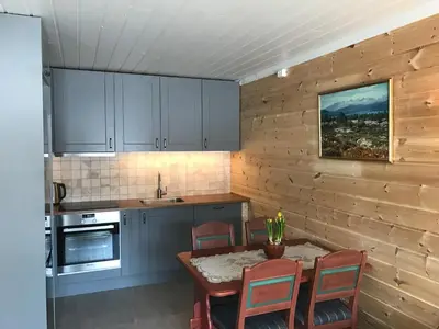 a kitchen with blue cabinets and a table and chairs at Rondaplassen in Kvam
