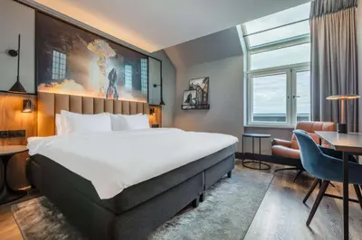 a hotel room with a large bed and a desk at Radisson Blu Royal Garden Hotel, Trondheim in Trondheim