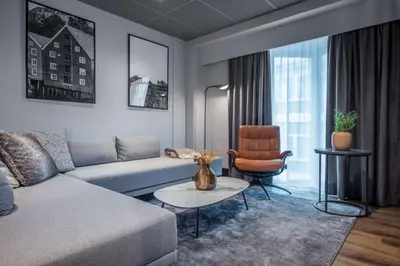 a living room with a couch and a chair at Radisson Blu Royal Garden Hotel, Trondheim in Trondheim