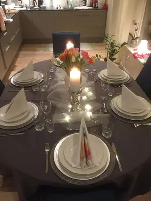 a table with a candle and plates and a candle holder at Frydenlund in Balestrand