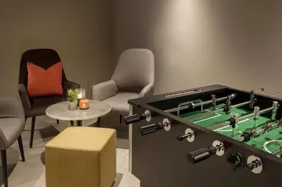 a living room with a foosball table and chairs at Scandic Kokstad in Bergen