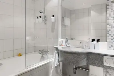 a bathroom with a sink and a shower and a tub at Scandic Bergen City in Bergen