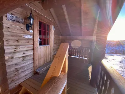 a wooden cabin with a porch and a window at Hakkesetstølen Fjellstugu in Geilo