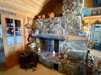 a room with a stone fireplace in a cabin at Hakkesetstølen Fjellstugu in Geilo