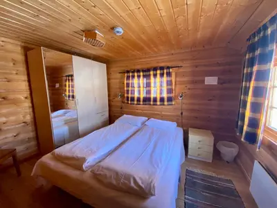 a bedroom with a bed in a wooden room at Hakkesetstølen Hytter in Geilo