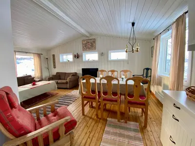 a dining room and living room with a table and chairs at Hakkesetstølen Hytter in Geilo