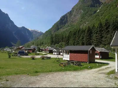 a group of houses in front of a mountain at Gudvangen Camping in Gudvangen