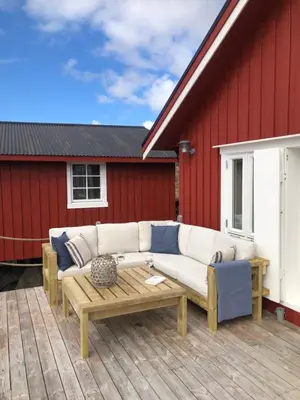 a white couch sitting on a wooden deck at The Boathouse in Råkvåg