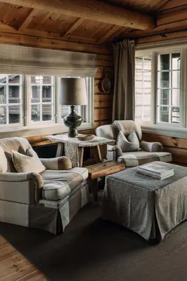 a living room with couches and a table and windows at Storfjord Hotel in Skodje