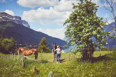 a woman standing next to a fence with a horse at Sommerhotellet in Vang I Valdres
