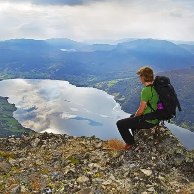 a person with a backpack sitting on top of a mountain at Sommerhotellet in Vang I Valdres