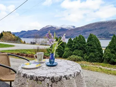 a table with a vase of flowers on it at 8 person holiday home in EIDSVÅG in Eidsvåg