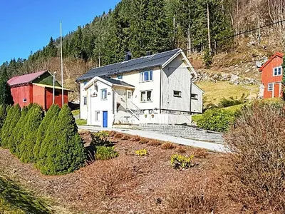 a white house with a red barn on a hill at 8 person holiday home in EIDSVÅG in Eidsvåg