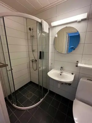 a bathroom with a shower and a sink at Nes Gard in Høyheimsvik