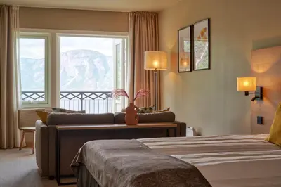 a hotel room with a bed and a couch and a window at Vøringfoss Hotel in Eidfjord