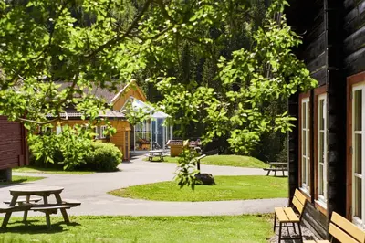 a picnic table and benches outside of a building at Kleivstua Hotel near Krokskogen in Sundvollen