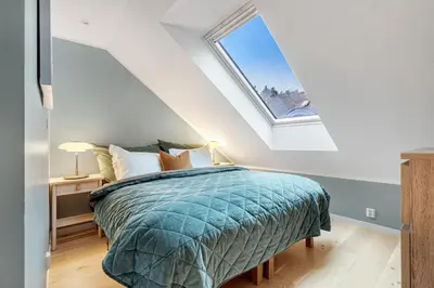 a bedroom with a bed and a window at Høyden Apartments in Bergen