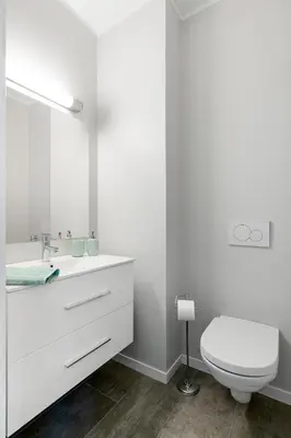 a white bathroom with a toilet and a sink at Høyden Apartments in Bergen