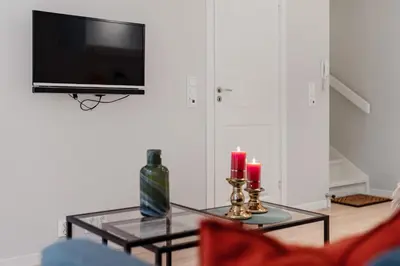 a living room with a table with two candles and a tv at Høyden Apartments in Bergen