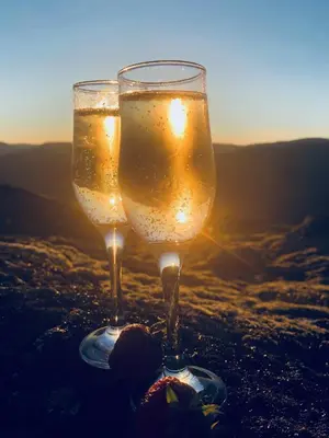 two glasses of champagne in front of the sunset at Grønset Skysstasjon in Vinjeøra