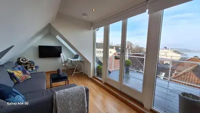 a living room with a couch and a large window at Penthouse with perfect location and spectacular view in Bergen