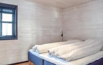 a bed in a room with a wooden wall at Amazing Home In Jøsenfjorden With Sauna in Gullingen