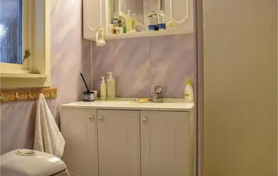 a bathroom with a white sink and a mirror at Lovely Home In Skånevik in Skånevik