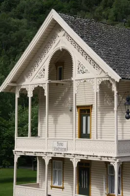 a white house with a gambrel roof at Lindstrøm Hotel in Lærdalsøyri