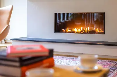 a living room with a fire place in the wall at Lindstrøm Hotel in Lærdalsøyri