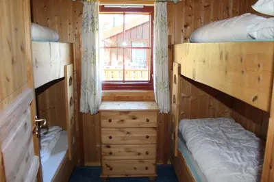 a room with two bunk beds and a window at Ådnebu by Norgesbooking - cabin with 3 bedrooms in Geilo