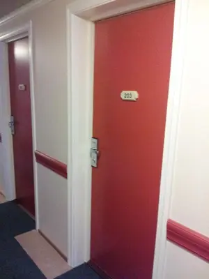 a red door with a sign on it in a room at Motell Nor-Kro in Bromma