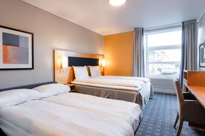 a hotel room with two beds and a window at Scandic Kristiansund in Kristiansund