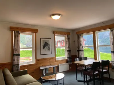 a living room with a couch and a table and windows at Winjum Apartments Aurland Stegastein in Aurland