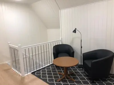 a room with two chairs and a table and a lamp at Balestrand Fjordapartments in Balestrand