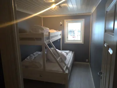 a small room with bunk beds with a window at Sogndal ski- and mountain cabin in Sogndal