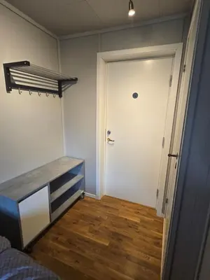 a bedroom with a door and a wooden floor at Vestavind hytter og rom AS in Ålesund