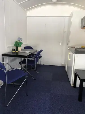 a meeting room with chairs and a table and a white wall at Rena HOSTEL EINARA in Rena