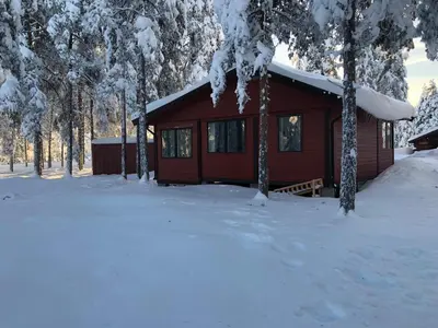 a log cabin in the snow with trees at Rena Hostel IVAR in Rena