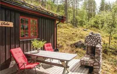 a wooden deck with a table and chairs outside a cabin at Four-Bedroom Holiday Home In Rendalen in Rendalen