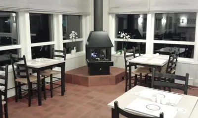 a restaurant with a fireplace in the middle of the room at Lærdal Ferie- og Fritidspark in Lærdalsøyri