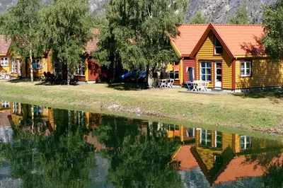 a log cabin next to a body of water at Lærdal Ferie- og Fritidspark in Lærdalsøyri