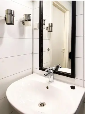 a white sink in a bathroom with a mirror at Mjøsvang Kafe in Vang I Valdres
