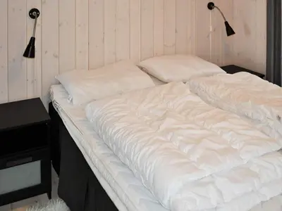 a large white bed with two pillows on it at 10 person holiday home in Øyer in Øyer