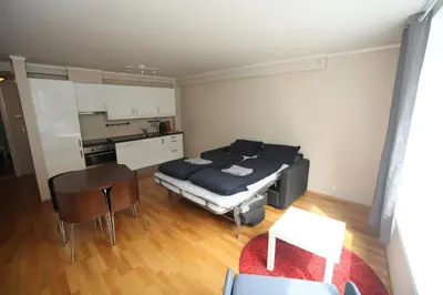 a living room with a bed and a kitchen at Bergen's Best Location in Bergen