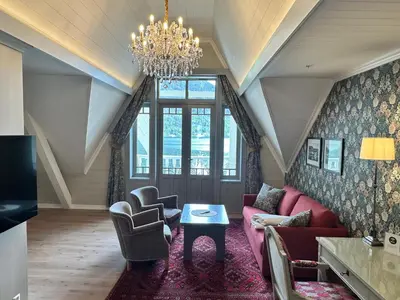 a living room with a pink couch and chairs at Hofslund Fjord Hotel in Sogndal