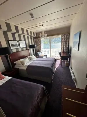 a hotel room with two beds and a window at Hofslund Fjord Hotel in Sogndal